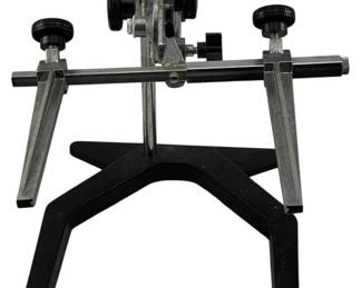 1205 - Metal Holder Stand 9"x12"x10" (Description): Metal holder stand featuring a sturdy black base with chrome-finished adjustable arms. The stand includes multiple adjustment knobs for precise positioning and features two parallel extending arms with adjustable clamps. Measures 9" x 12" x 10".