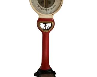 173 - Toledo Scale Co. Lollipop Scale 78x25x31 (Description): Vintage Toledo Scale Company lollipop-style floor scale featuring the classic "Your Weight Free" and "Toledo-No Springs" dial face. This standing penny scale displays a red and cream painted body with a black cast iron base. The circular dial head sits atop a distinctive handle-shaped neck, characteristic of early 20th century Toledo scales. Measures 78 inches tall by 25 inches wide by 31 inches deep.