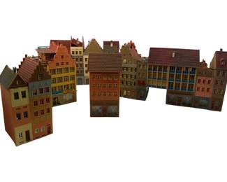 315 - Group Lot of Faller Train Display Buildings (Description): A group lot of Faller train display buildings featuring a variety of European-style townhouses and structures. The collection includes colorful multi-story buildings with distinctive architectural details such as stepped gables, tiled roofs, and decorative facades in shades of orange, yellow, cream, pink, and blue. Ideal for model railroad layouts or dioramas. Measures 7 inches.