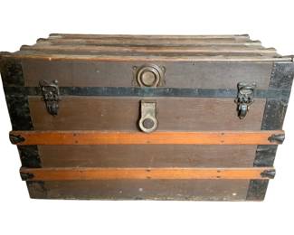 163 - Metal & Wood Trunk w/Tray 20"x32"x17.5" (Description): Antique metal and wood trunk with insert. This flat-top steamer trunk features wooden slat reinforcements, metal corner brackets and strapping, and original hardware including side handles and a front clasp closure. The trunk retains its interior insert tray. Shows authentic age-related wear consistent with period use. Measures 20 inches high by 32 inches wide by 17.5 inches deep.