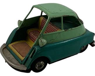 1090 - BMW Isetta Tin Litho Car 4"x4"x4" (Description): Vintage BMW Isetta tin lithographed toy car featuring a two-tone green body with a lighter mint green roof and darker teal lower body. The front-opening door reveals a cream and red checkered interior with detailed lithographed seats. This charming friction or display toy captures the iconic bubble car design of the 1950s Isetta microcar. Shows age-appropriate wear consistent with vintage tin toys. Measures 4" x 4" x 4".