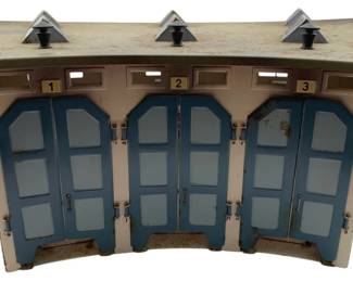 359 - Marklin Germany Metal 3 Stall Roundhouse (Description): Marklin Germany metal 3 stall locomotive roundhouse. This vintage tin structure features three numbered bays with hinged double doors and decorative roof vents. Measures 5 inches high by 17 inches wide by 14 inches deep.