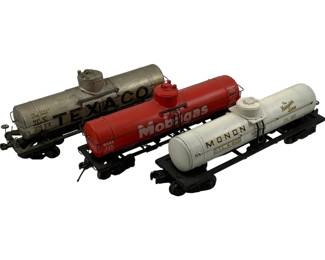 1193 - 3pc. O Scale Tank Car Trains 3"x9"x2.5" (Description): Set of three O scale model tank car trains. The collection includes a silver Texaco tank car, a red Mobilgas tank car, and a white Monon tank car, along with a white tank car marked "The Hoosier Line." Each car features detailed markings and sits oblack truck assemblies. Measures 3"x9"x2.5".