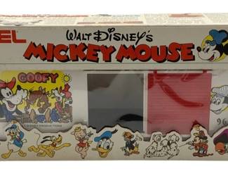 832 - Lionel Goofy Box Car O Scale in Box (Description): Lionel Goofy Box Car in O Scale, part of the Walt Disney Mickey Mouse Express series. The car comes in its original box featuring colorful illustrations of classic Disney characters including Mickey Mouse, Minnie Mouse, Donald Duck, Goofy, Pinocchio, and others. The box car itself displays Goofy artwork. Dated 1977 Walt Disney Productions.