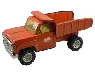 836 - Vtg Tonka Dump Truck 16"x13.5"x6" (Description): Vintage Tonka dump truck in orange painted pressed steel with yellow tinted windows. Features a working tilting dump bed, chrome-finished front bumper and grille, and black rubber tires with white plastic wheel hubs. Shows age-appropriate wear consistent with play use. Measures 16 inches long by 13.5 inches high (with bed raised) by 6 inches wide.