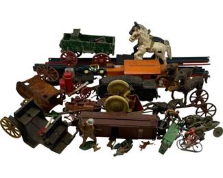 1157 - Lot Assorted Vintage Cast Iron & Metal Toys (Description): A collection of assorted vintage toys featuring cast iron and metal pieces. The lot includes horse-drawn wagons and carts, train cars and locomotives, a rocking horse figure, toy soldiers and figures, a cyclist figure, and various wheeled vehicles. The pieces show age-appropriate wear and patina consistent with antique and vintage toys, with some exhibiting original paint in various states of preservation.