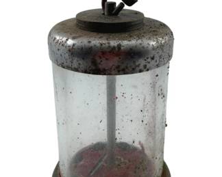 371 - Vintage Glass Cylinder Bank 5.5"x3" (Description): Vintage glass cylinder bank featuring a clear glass body with metal top and base. The bank includes a coin mechanism on top. Measures 5 1/2" x 3".