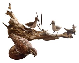 391 - Group Lot of 2 Bird Statues 11"x25"x7" (Description): Group lot of two bird statues. The collection features carved and painted bird figures displayed on naturalistic driftwood bases. Measurements: 11 inches by 25 inches by 7 inches.