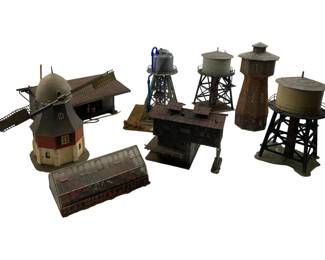 331 - Model Train Display Set w/ Buildings 7" (Description): Model train display set featuring an assortment of detailed miniature buildings and structures. The collection includes multiple water towers in various styles, a charming windmill with traditional European design, an industrial warehouse or shed, agreen house structure, and additional rustic buildings. Each piece is expertly crafted with realistic weathering and architectural details suitable for HO or similar scale