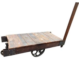 408 - Lineberry Cart by Weber & Pitcher (Description): Lineberry cart manufactured by Weber & Pitcher. This industrial cart features a wooden plank platform mounted on a metal frame with cast iron wheels and a long handle for maneuvering. Measures 14.5 inches high by 55 inches long by 24 inches wide.