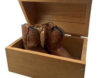 411 - Wood Box & Child's Cowboy Boots 8"x10"x7" (Description): A wooden box with hinged lid and red handle, accompanied by a pair of child's leather cowboy boots with decorative stitching. The box measures 8 inches by 10 inches by 7 inches.