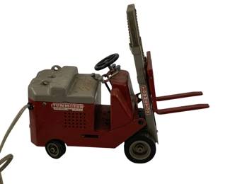934 - Crosbi Electric Forklift Toy 11"x14"x5" (Description): Crosbi Electric Forklift Toy featuring a red and gray pressed steel body with "Towmotor - The One-Man Gang" decals. This vintage remote-controlled toy includes a working lift mechanism, black steering wheel, and rubber wheels. The forklift has an attached corded remote control for operation. Measures 11" x 14" x 5". Used as is electric/electronic/mechanical item. No guarantee all components, untested.
