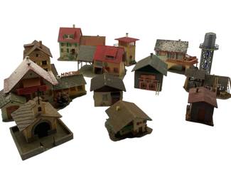 308 - Faller Train & Display Houses Group Lot (Description): A collection of Faller miniature train and display houses, ideal for model railroad layouts or dioramas. The lot includes a variety of structures such as residential homes, commercial buildings, a church with arched entrance, a water tower, and various outbuildings. The buildings feature diverse architectural styles with detailed roofing, facades, and decorative elements in an assortment of colors including red, gray,