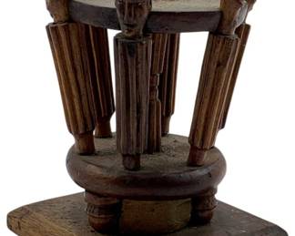 111 - Vintage Carved Wooden Trinket 3.5"x2.5" (Description): Vintage carved wooden trinket featuring a circular tiered design with five carved figural posts topped with human head details. The posts extend between two circular platforms mounted on a square wooden base with ball feet. The piece displays a warm brown patina throughout. Measures 3 1/2" x 2.5".