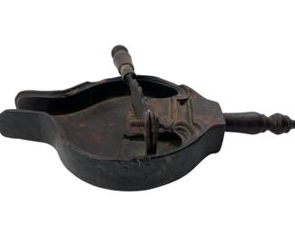 182 - Vtg Wood & Metal Chocolate Cutter (Description): Vintage wood and metal chocolate cutter featuring a carved wooden body with a dark patina and turned wooden handles on either end. The mechanism includes a metal cutting wheel mounted in the center for portioning chocolate. Measures 3 inches high by13 inches wide by 6.5 inches deep.