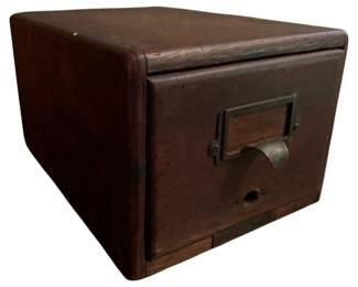 145 - Vtg Wood File Drawer Box 6"x7.5"x12" (Description): Vintage wooden file drawer box featuring a single pull-out drawer with brass label holder and curved metal pull handle. The piece has a rich dark wood finish with rounded edges and shows authentic age-appropriate patina. A keyhole on the drawer front suggests it once had a locking mechanism. Measures 6" x 7.5" x 12".