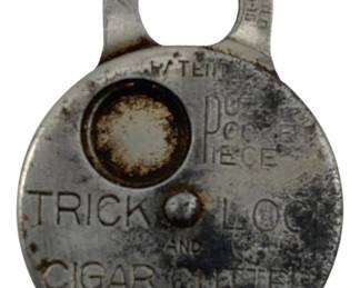 663 - Vtg Trick Lock and Cigar Cutter 1.5"x1.25" (Description): Vintage trick lock and cigar cutter combination tool. This novelty piece features a dual-purpose design serving as both a functional lock mechanism and cigar cutter. Measures 1 1/2" x 1.25".
