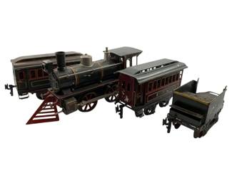 16 - Group Lot of Vtg Tin Trains & Train Cars (Description): Group lot of vintage tin toy trains and train cars including a black steam locomotive with gold pinstriping and red cow catcher, a maroon passenger car with windows, and a coal tender car. The set features hand-painted details characteristic of early 20th century tin lithograph toys. Measures 5"x11"x3".