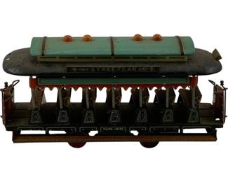 1121 - Vtg Tin Litho Streetcar Trolley No. 45 (Description): Vintage tin lithograph streetcar trolley marked "No. 45" and "Streetcar" on the side panel. This open-air style trolley features a teal roof with three orange dome lights, decorative scalloped canopy trim in red and white, and painted passenger fres in the interior seats. The body is finished in dark green with cream-colored bell graphics along the lower panels. Complete with detailed conductor figures at each end. Measures 4