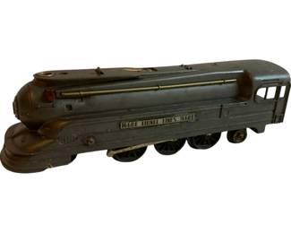 1172 - Lionel 027 Locomotive 3"x9.5"x2.25" (Description): Lionel 027 locomotive in gunmetal gray with brass accents. This streamlined engine features the classic Lionel Lines nameplate with model number 1668E displayed on the side. The locomotive shows vintage patina with wear consistent with age and use. Measures 3 inches high by 9.5 inches long by 2.25 inches wide.