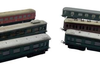 277 - Group Lot of 6 Marklin Passenger Cars (Description): The cars feature various color schemes including red, green, blue, and maroon finishes. Each car measures 2 inches by 2 inches by 9 inches.