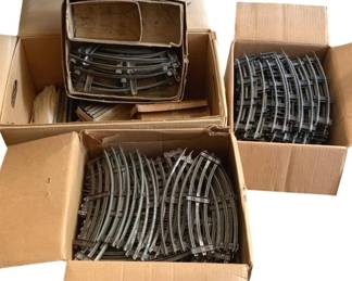 500 - Lot Train Tracks O Scale (Description): A lot of O scale train tracks. The collection includes multiple pieces of curved and straight track sections suitable for model train layouts.