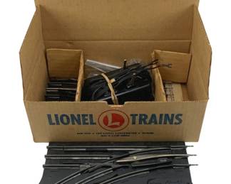 866 - Lionel #027 Track Set in Box O Scale (Description): Lionel #027 track set in O scale, housed in its original Lionel Trains branded cardboard box. The set includes various track pieces including curved sections and a remote control switch section. Additional components and wiring are visible within the box. Made by The Lionel Corporation.