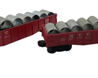 341 - Pr Lionel Gondola Cars w/ Culvert Pipe Loads (Description): Group of two Lionel gondola cars with culvert pipe loads. These NYC-marked model train cars feature removable silver-gray culvert pipe cargo. Each car measures 2 inches by 11 inches by 2 inches.
