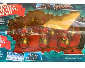 498 - Santa's Marching Band in Box (Description): Santa's Marching Band in original box. This festive holiday decoration features a string of musicians with brass bells that play Christmas carols.