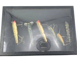 605 - Shadowbox w/ 6 Fishing Lures 2"x12"x8.5" (Description): Shadowbox display case containing six fishing lures. The lures feature various painted finishes and are equipped with treble hooks. Measures 2 inches deep by 12 inches wide by 8.5 inches tall.