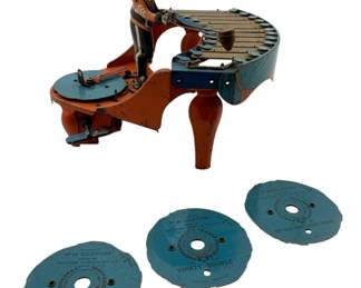 23 - Wolverine Zilotone Wind Up Musical Toy (Description): Wolverine Zilotone wind up musical toy with 3 extra discs. This charming vintage lithographed tin toy features a uniformed figure playing a xylophone, with a mechanical wind-up mechanism that plays music when the interchangeable discs are inserted. The included discs feature titles including "Listen to the Mocking Bird," "Yankee Doodle," and "My Old Kentucky Home." The toy displays vibrant orange and blue coloring