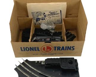 865 - Lionel #027 Track Set in Box O Scale (Description): Lionel #027 Track Set in O Scale, housed in its original Lionel Trains box. The set includes curved and straight track sections, control components, and original paperwork including a "Romance of Model Railroading" booklet. A vintage model railroad accessory set from The Lionel Corporation.