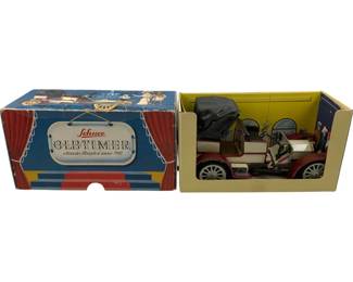 1177 - Schuco Old Timer 1902 Mercedes in Box (Description): Schuco Old Timer 1902 Mercedes Simplex model car in original box. This vintage tin toy features a detailed replica of the classic automobile with a folding top, seated driver figure, and period-appropriate styling in red and cream colors. The car comes in its colorful original Schuco Oldtimer presentation box with theatrical curtain design.