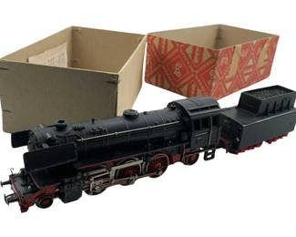 255 - Marklin HO Scale Steam Locomotive w/ Tender (Description): Marklin train car featuring a black steam locomotive with red wheels and undercarriage, accompanied by its coal tender. The locomotive displays classic German engineering styling with detailed metal construction. Includes original Marklin branded box. Measures 2"x5"x2".