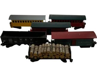 1149 - 6pc. Lot O Scale Trains 3"x8"x2" (Description): A collection of six O scale train cars measuring 3 inches by 8 inches by 2 inches. The lot includes two vintage-style passenger cars with gray and dark blue roofs over yellow and burgundy bodies, a Norfolk & Western hopper car in black, a U.S. Mailboxcar with red roof and dark green body, and a flatcar loaded with miniature logs. Each car features period-appropriate detailing and rolling wheels.