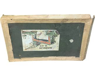 1133 - Marklin #104 Construction Set Original Box (Description): Marklin #104 Construction Set for Cabin original box. This vintage box features the classic Marklin green label with a colorful lithographed illustration depicting the construction set contents. The cardboard box shows age-appropriate wear with someedge wear and surface aging consistent with its vintage origins. Box only, contents not included.