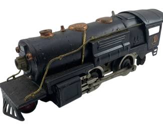 319 - O Gauge Lionel Locomotive 3"x3"x9" (Description): O gauge Lionel locomotive in classic black finish with copper-tone accents. This vintage die-cast metal steam engine features the distinctive Lionel logo on the cab, brass-colored piping details along the boiler, and functioning wheels with connecting rods. Shows authentic age-related wear consistent with vintage toy trains. Measures 3" x 3" x 9".