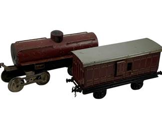 1002 - 2pc. Set O-Scale Train Cars 5"x11"x.5" (Description): A two-piece set of O-scale train cars. The set includes a tanker car and a boxcar with a gray roof. Each car measures approximately 5 inches by 11 inches by .5 inches.