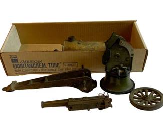 1047 - Marklin Cannon Parts #3 (Description): Marklin cannon parts, lot #3. This lot includes assorted components from a Marklin cannon, including what appears to be the main barrel assembly, carriage parts, and wheel. The pieces show age-appropriate patina consistent with vintage Marklin military toy production.