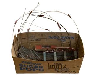 1101 - Box Lot Vtg Train Items (Description): Including metal bridge sections, track pieces, and assorted railway components. The lot includes what appears to be a Lionel Trains box among the contents. Various metal wire forms and structural elements are included, suitable for model railroad layouts or displays.