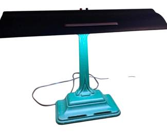 146 - Green Metal Desk Lamp 15"x18"x8" (Description): Green metal desk lamp featuring an Art Deco style base and stem with a black rectangular shade. The lamp has a distinctive teal green finish on the stepped base and fluted column. Measures 15 inches wide by 18 inches tall by 8 inches deep. Used as is electric/electronic/mechanical item. No guarantee all components, untested.