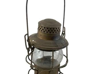 609 - C & O Railroad Lantern 15"x7.5"x6" (Description): C & O Railroad lantern featuring a clear glass globe and metal frame with wire cage construction. The lantern shows classic railroad styling with a ventilated top and bail handle. Measures 15 inches by 7.5 inches by 6 inches.