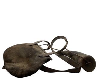 8 - Leather Pouch w/ Powder Horn 8"x10.5 - 8"x3" (Description): Antique leather pouch with accompanying powder horn. The pouch features a rounded flap design with leather strap attachments, showing significant age and patina consistent with period use. The powder horn displays a dark, weathered finish with a wooden stopper end. The leather has developed a rich, aged character throughout. Pouch measures 8" x 10.5", powder horn measures 8" x 3".