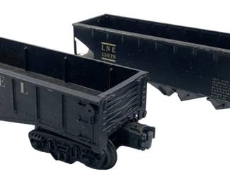 202 - Lionel & Lehigh Train Cars 2"x2"x9" (Description): A pair of vintage model train cars featuring a Lionel gondola car and a Lehigh hopper car. Both cars are finished in black and display their respective railroad markings. Each car measures 2 inches by 2 inches by 9 inches.