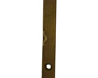 1217 - Antique Wood Level 28"x3" (Description): Antique wood level featuring a brass or bronze faceplate with a small spirit level window and a center keyhole opening. The elongated rectangular form shows mounting holes at top and bottom. Measures 28 inches by 3 inches. Shows aged patina consistent with age and use.