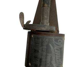 4 - Dandy Pencil Sharpener 5"x8"x2.75" (Description): Antique Dandy pencil sharpener featuring cast iron construction with a distinctive triangular blade housing and wooden ball-turned handle. The cylindrical body displays embossed "Dandy" branding and retains its original dark patina. A lever mechanism on top operates the sharpening function. Measures 5" x 8" x 2.75".