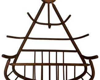 167 - Vintage Bentwood Hat & Coat Rack 33"x27"x9" (Description): Vintage bentwood hat and coat rack featuring a distinctive triangular wall-mounted design. The piece showcases classic bentwood construction with curved wooden elements forming a decorative frame. Multiple extending pegs provide ample hanging space for hats and coats, while the lower curved basket section offers additional storage. The warm brown finish displays natural patina consistent with age. Measures 33 inches high