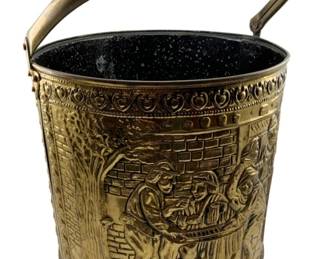 56 - Brass Bucket w/Handle 12"x11.5"x12" (Description): Brass bucket with swing handle, featuring embossed decorative relief depicting a tavern scene with figures gathered around a fireplace. The cylindrical body showcases detailed repousse work including trees, brick walls, and period-dressed figures ina convivial setting. The upper rim features an ornamental border of repeating circular motifs. Interior is finished in dark enamel. Measures 12" x 11.5" x 12".