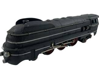 310 - Marklin Locomotive 2"x2"x7" (Description): Marklin locomotive in black finish with streamlined Art Deco styling. This O-gauge model features red and black wheels with detailed running gear and silver accent striping along the body. The locomotive displays classic pre-war German design elements typical of Märklin's high-quality tinplate production. Measures 2 inches by 2 inches by 7 inches.