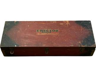 1229 - Vtg A.C. Gilbert Erector Set in Wood Box (Description): Vintage A.C. Gilbert Erector Set housed in its original wooden storage box. The box features a red and dark blue/black painted exterior with the classic Erector logo and 'The World's Greatest Toy' tagline visible on the lid. The metal hinged latches remain intact. The box shows significant wear consistent with age and use, including scratches, paint loss, and patina. Measures 6"x29"x10.5".
